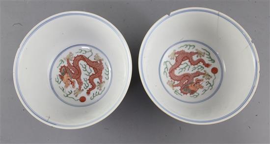 A pair of Chinese wucai dragon and phoenix bowls, Qianlong mark and of the period (1736-95), diameter 15.6cm, some damage